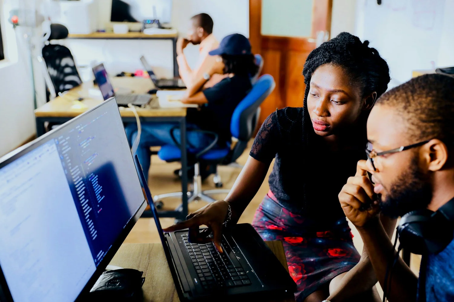 Two learners collaborating at a laptop